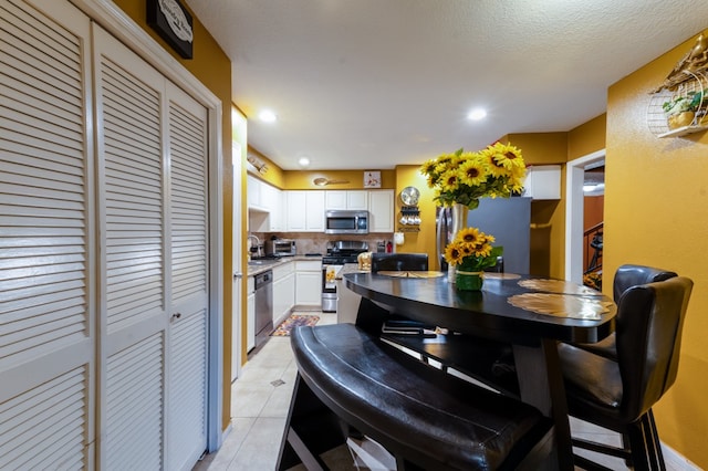 tiled dining space with a textured ceiling