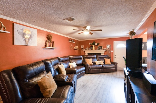 living room with a textured ceiling, ceiling fan, light wood-type flooring, and ornamental molding