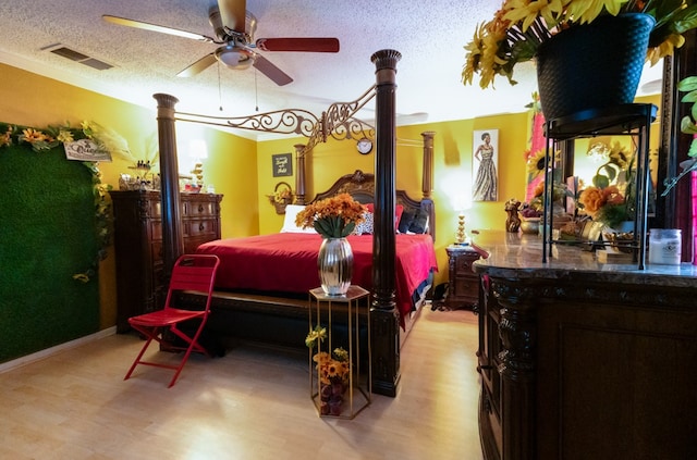 bedroom with a textured ceiling, ceiling fan, and light wood-type flooring