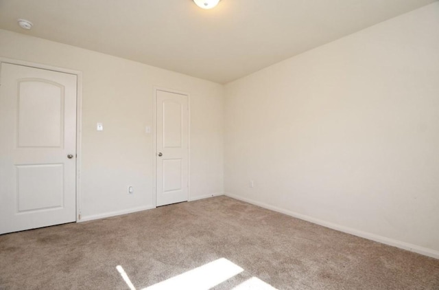 unfurnished room featuring light colored carpet