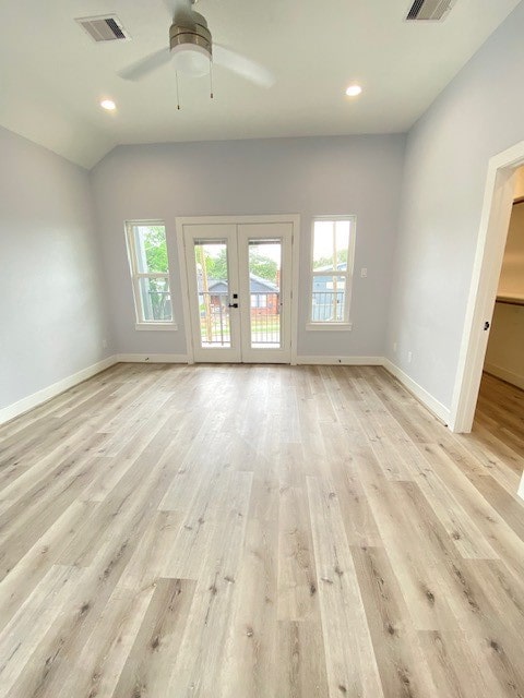 unfurnished living room with ceiling fan, light hardwood / wood-style floors, lofted ceiling, and french doors