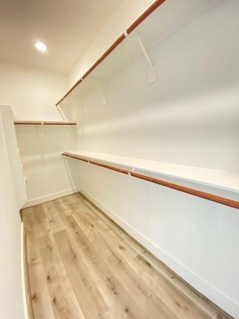 walk in closet with light wood-type flooring