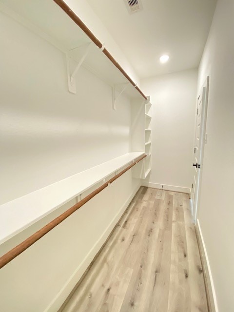 spacious closet with light hardwood / wood-style flooring