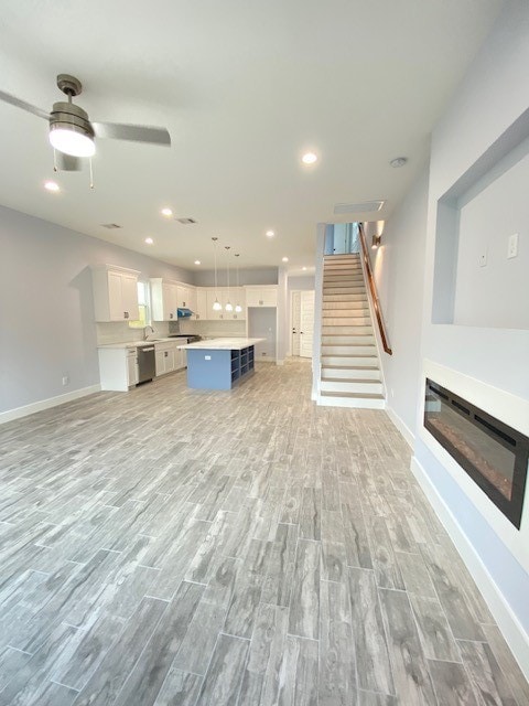 unfurnished living room with light hardwood / wood-style floors and ceiling fan