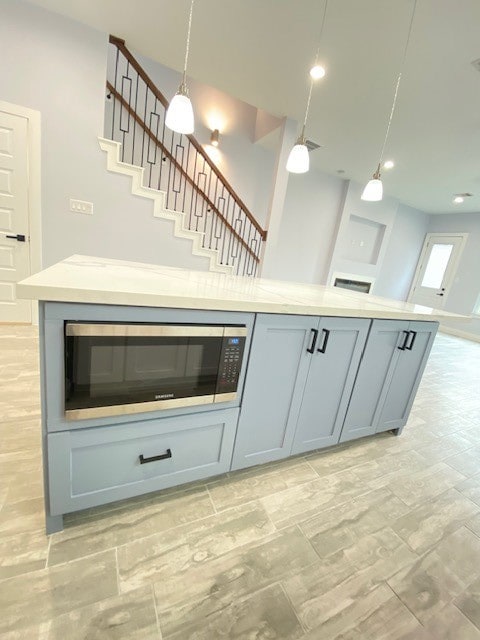 kitchen featuring decorative light fixtures and stainless steel microwave