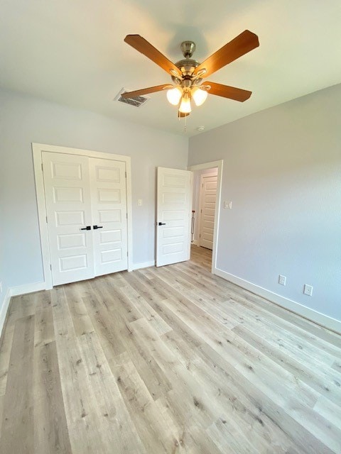 unfurnished bedroom with ceiling fan, light hardwood / wood-style floors, and a closet