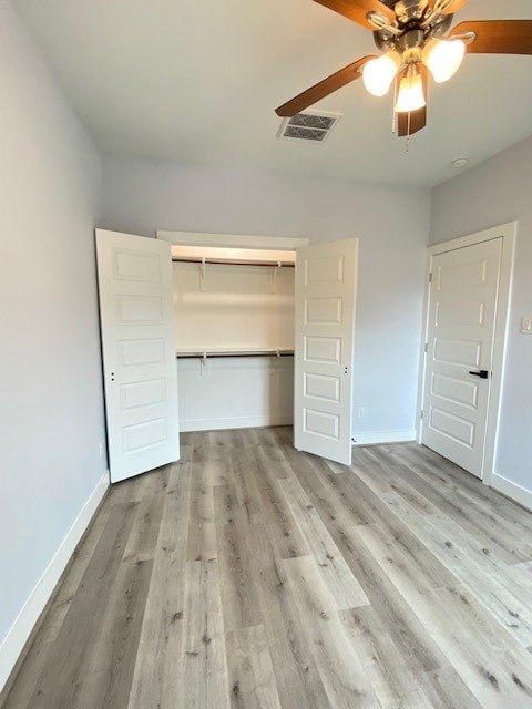 unfurnished bedroom with ceiling fan, a closet, and light hardwood / wood-style flooring