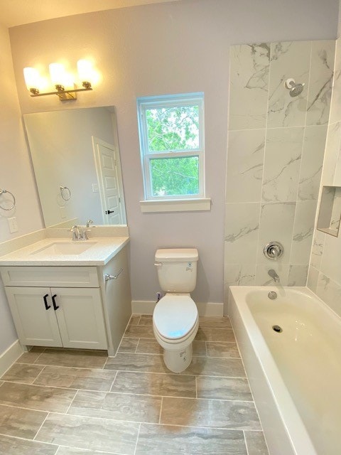 full bathroom with vanity, toilet, and tiled shower / bath