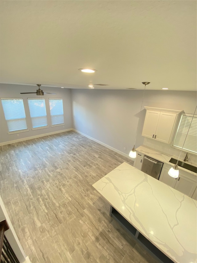 interior space with light hardwood / wood-style flooring, ceiling fan, lofted ceiling, and sink