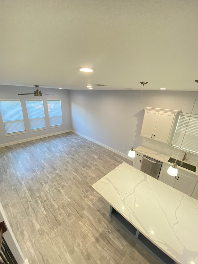 interior space with light wood-type flooring, ceiling fan, lofted ceiling, and sink