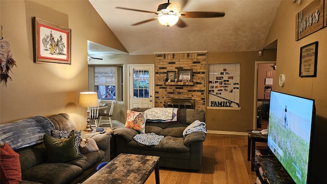 living room featuring ceiling fan, a brick fireplace, lofted ceiling, brick wall, and wood-type flooring