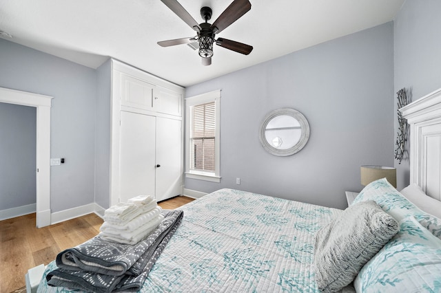 bedroom with a closet, light hardwood / wood-style flooring, and ceiling fan