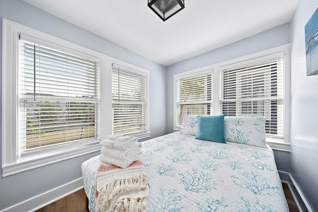 bedroom with dark hardwood / wood-style flooring