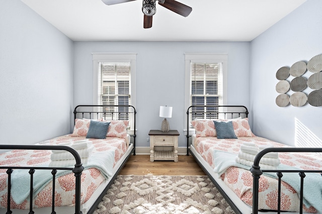 bedroom with light hardwood / wood-style floors, ceiling fan, and multiple windows