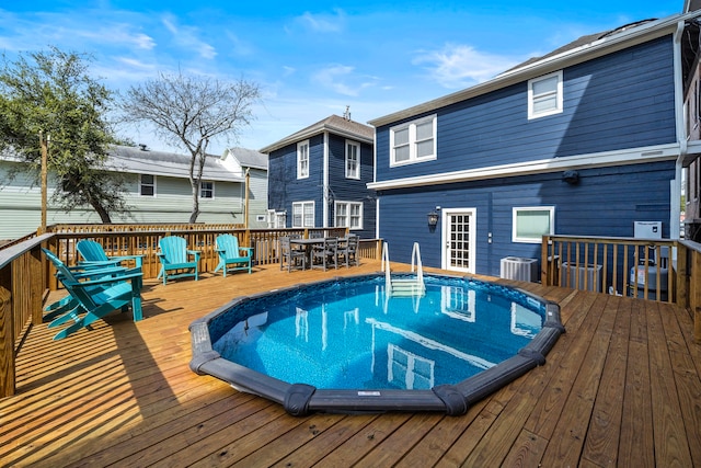 view of pool with central AC and a wooden deck