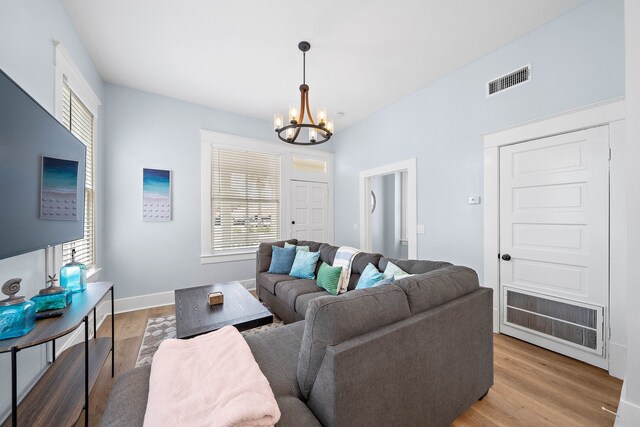 living room with light wood-type flooring and a chandelier