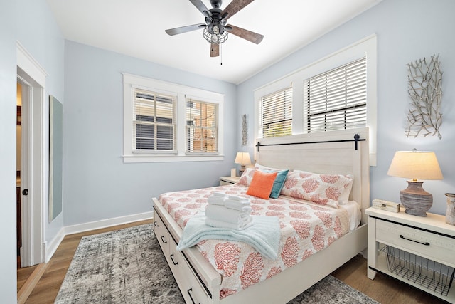 bedroom with dark hardwood / wood-style flooring and ceiling fan