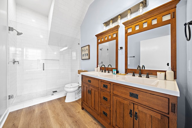 bathroom with oversized vanity, walk in shower, toilet, hardwood / wood-style flooring, and dual sinks