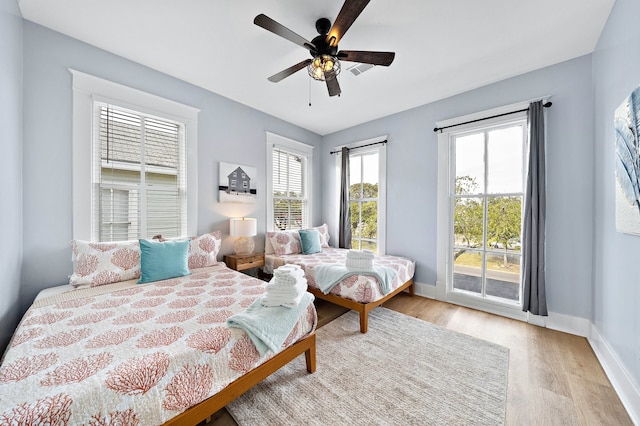 bedroom featuring ceiling fan, light hardwood / wood-style floors, and access to outside