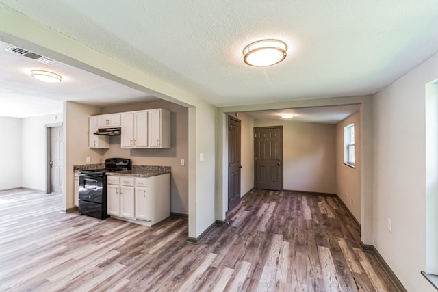 kitchen with a textured ceiling, white cabinets, hardwood / wood-style floors, and black range with electric stovetop