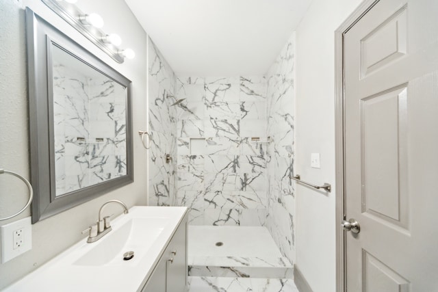 bathroom with vanity and a tile shower