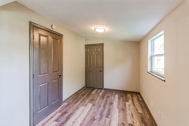 unfurnished bedroom with hardwood / wood-style flooring and lofted ceiling