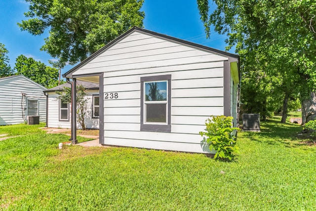 view of property exterior with a yard and central air condition unit