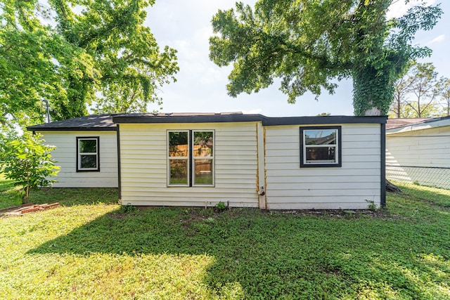 back of property featuring a lawn