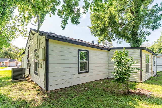 view of property exterior with a yard and central air condition unit