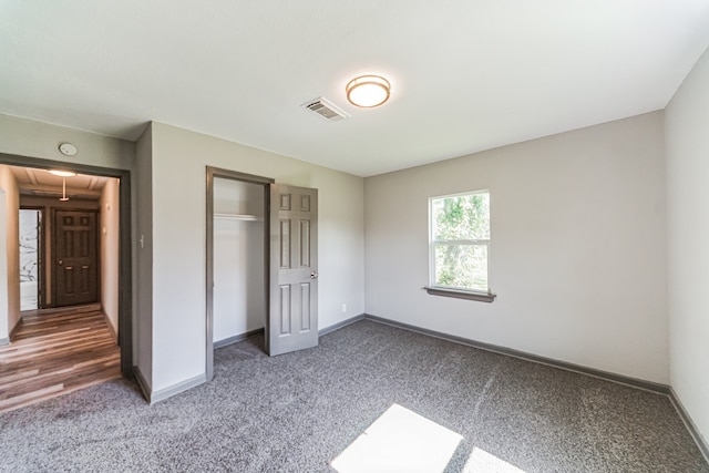 unfurnished bedroom with a closet and carpet flooring