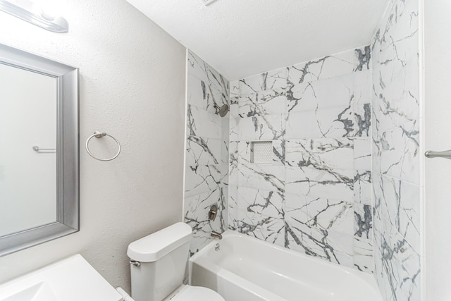 full bathroom with a textured ceiling, tiled shower / bath combo, vanity, and toilet