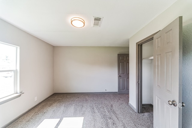 unfurnished bedroom with a closet and carpet floors