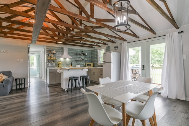 dining area featuring sink, dark wood-type flooring, lofted ceiling with beams, and french doors