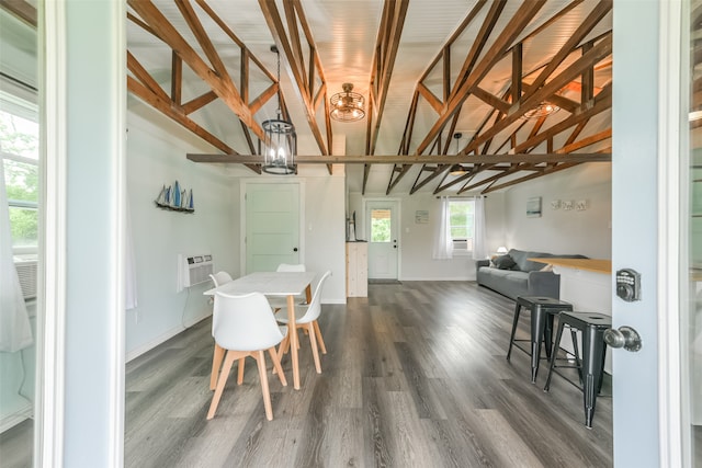 dining area with wood-type flooring, lofted ceiling with beams, and an AC wall unit