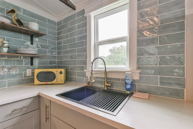 kitchen with tasteful backsplash, sink, and lofted ceiling