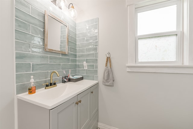 bathroom with a healthy amount of sunlight, vanity, and tasteful backsplash