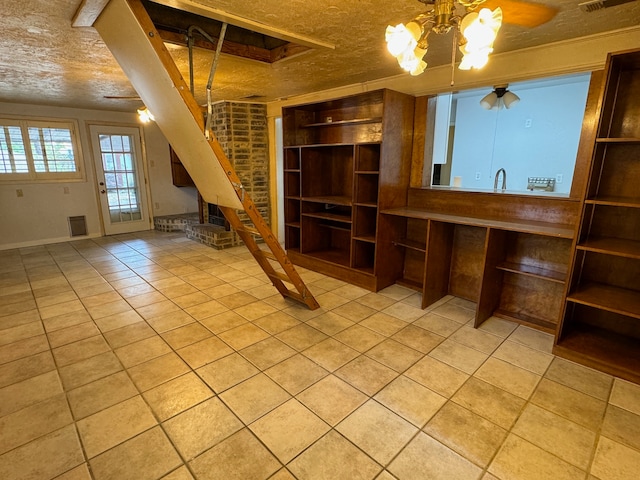 unfurnished living room featuring ceiling fan, a textured ceiling, and light tile flooring