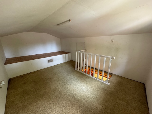 bonus room with vaulted ceiling and carpet floors