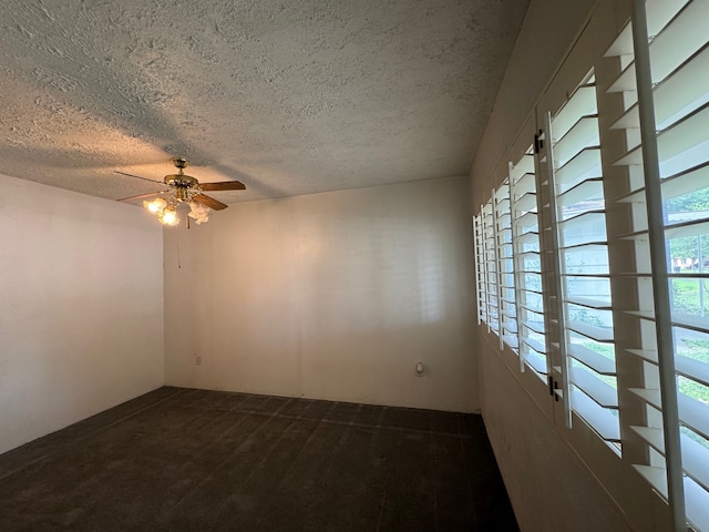 carpeted spare room with ceiling fan and a textured ceiling