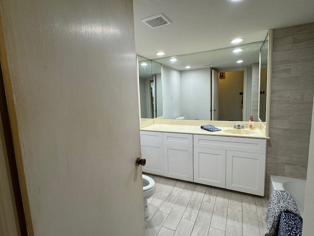 full bathroom featuring shower / tub combination, vanity, hardwood / wood-style flooring, and toilet