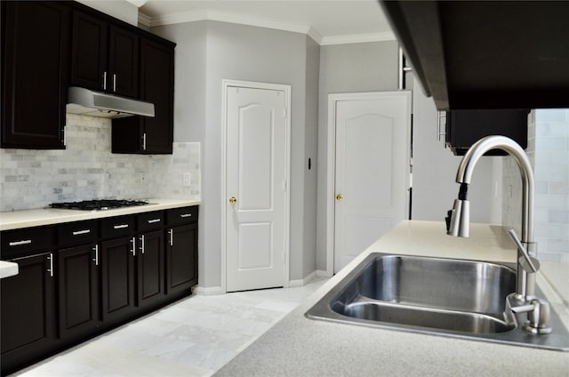 kitchen featuring sink, stainless steel gas stovetop, decorative backsplash, light tile patterned floors, and crown molding