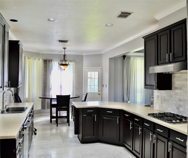 kitchen featuring appliances with stainless steel finishes, decorative backsplash, decorative light fixtures, ornamental molding, and sink