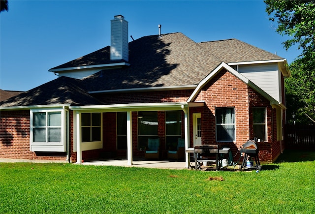 rear view of property with a yard and a patio area