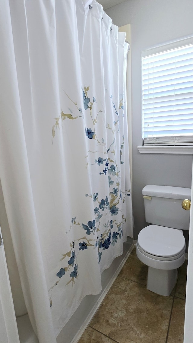 bathroom with toilet and a shower with shower curtain