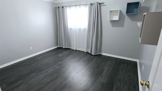 unfurnished room with crown molding and dark hardwood / wood-style flooring