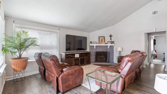 living room featuring wood-type flooring, vaulted ceiling, and a premium fireplace