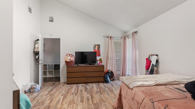 bedroom featuring high vaulted ceiling and light hardwood / wood-style flooring