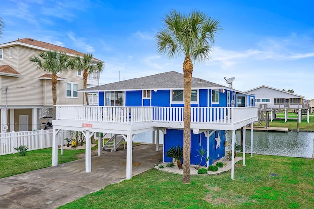 back of property with a yard and a water view