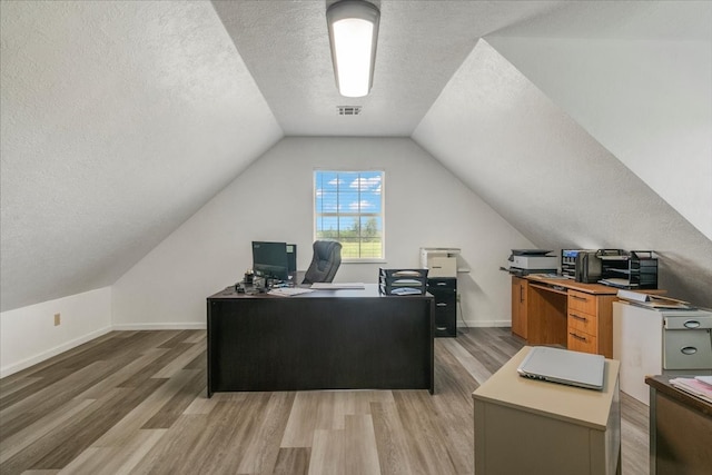 office area featuring wood-type flooring, a textured ceiling, and vaulted ceiling