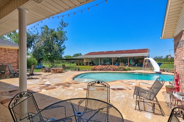 view of swimming pool with a patio and a water slide